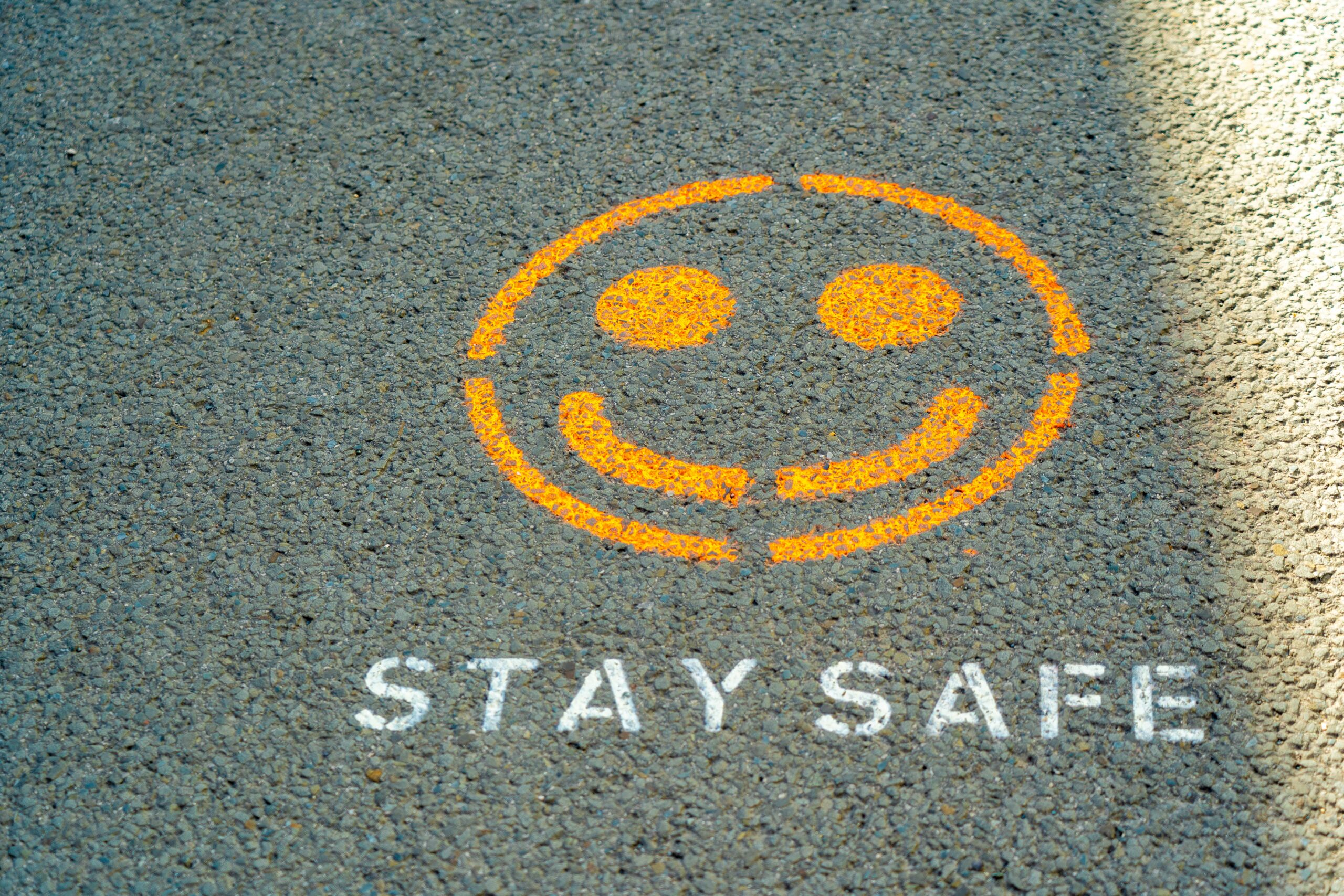 image of a yellow smiley face with white text saying stay safe on the road
