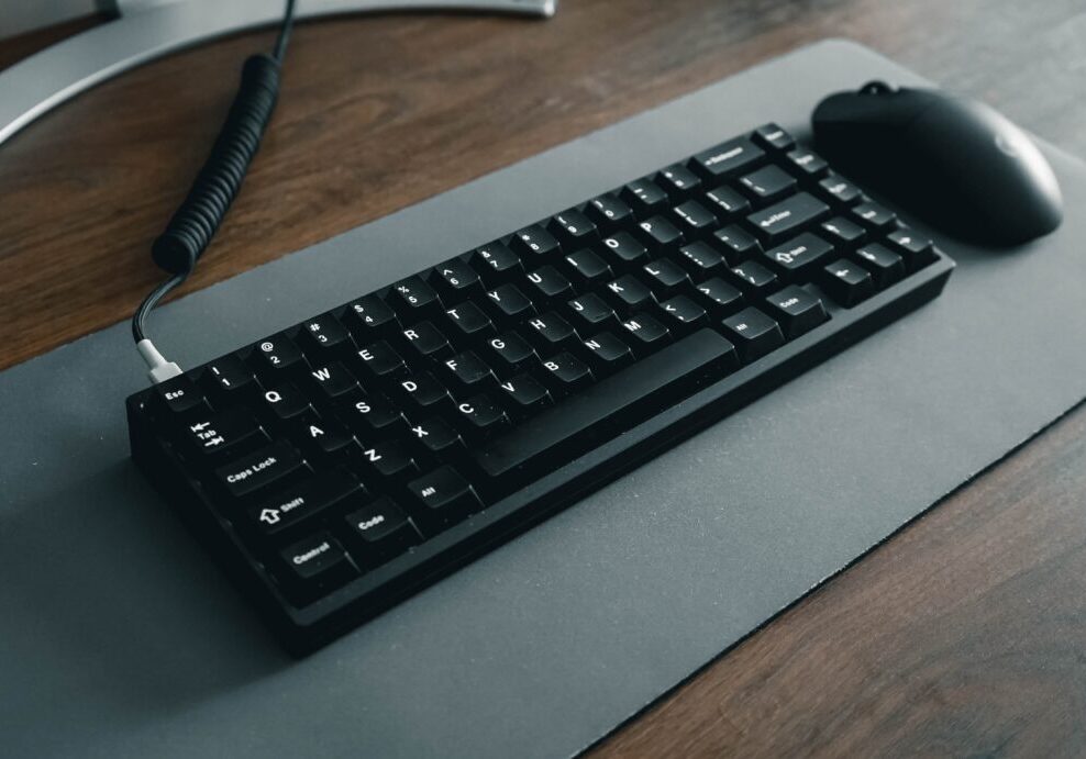 high angle of a keyboard and mouse on a black mat