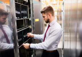 technician providing it service and inspecting server